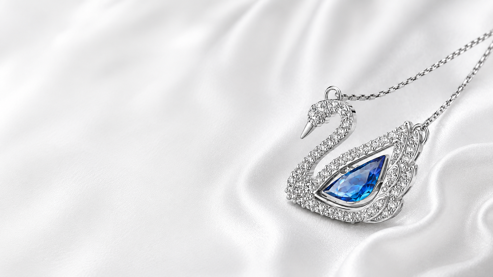 Collier Blue Swan argenté avec pierre bleue sur satin blanc